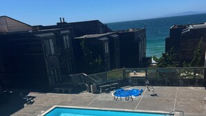 Ein Swimmingpool mit klarem, blauem Wasser, umgeben von einer Steindeck und mit Blick auf eine Wasserfläche.