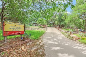 Ein Schild mit der Aufschrift 'CASAS De Wimberley' und Hinweisen zu 'CASA Grande', 'CASA Ranchero' und 'LA Castia'.