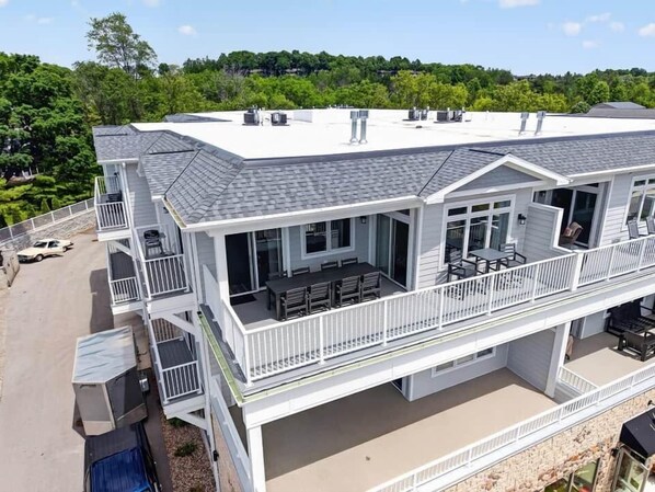 A two-story building with a balcony, outdoor seating, and a covered patio area.