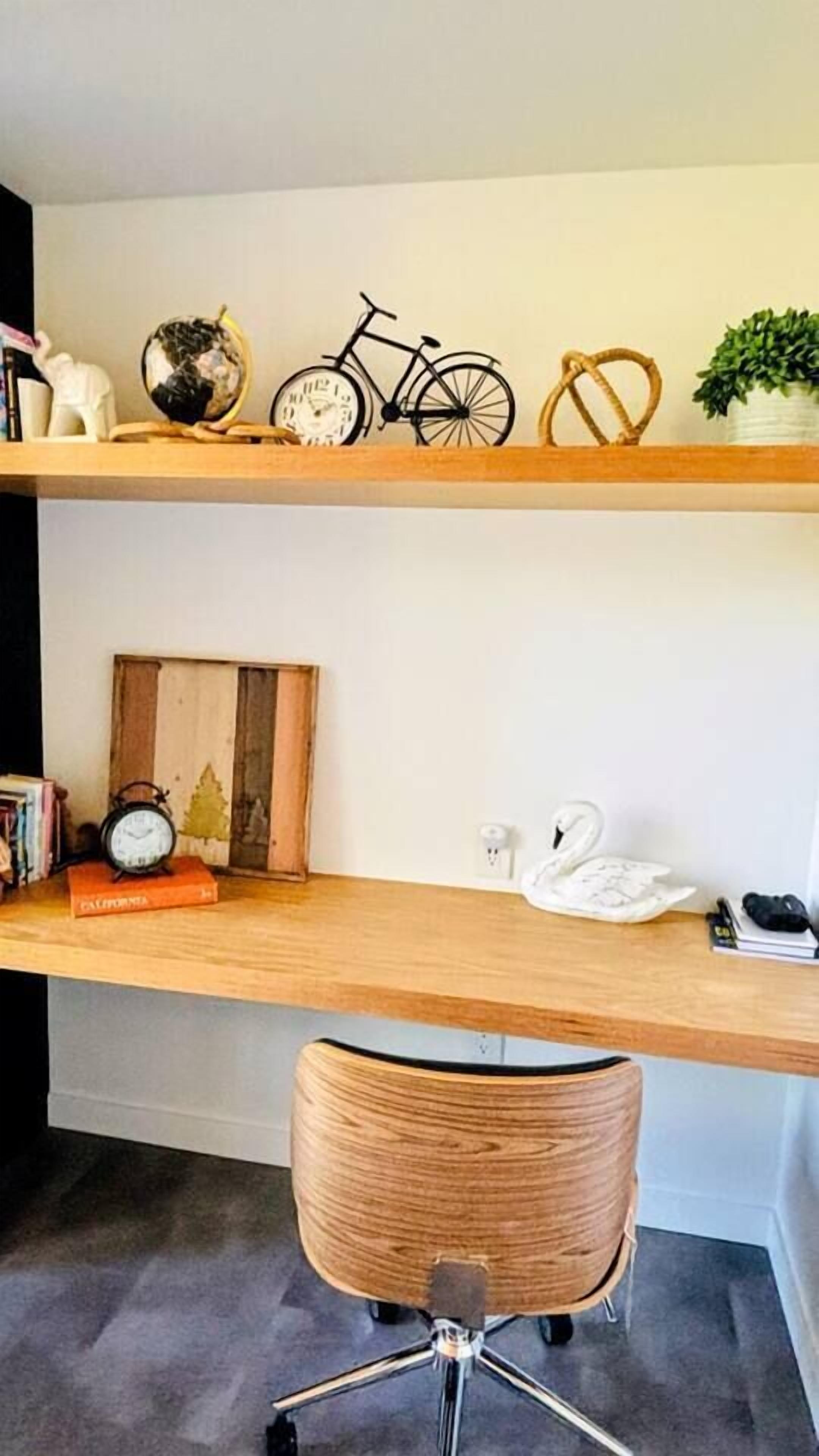 A wooden desk with a globe, bicycle, and swan decoration.