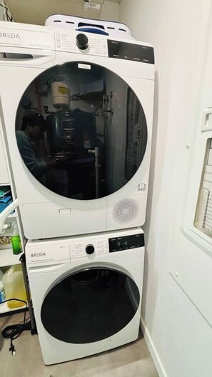 A stacked washer and dryer unit with a control panel and a visible door handle.