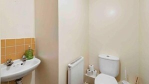 Un bagno con lavandino, water e termosifone.