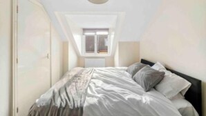 Una camera da letto con un letto, una finestra e una lampada a soffitto.
