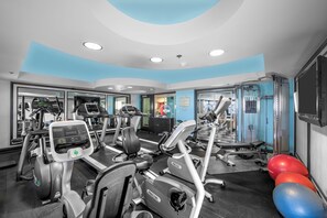 Ein Fitnessstudio mit Laufbändern, Crosstrainern und Fitnessbällen.