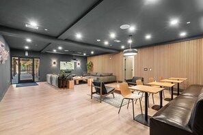 Ein modernes Interieur mit Holzboden, einer Couch, Tischen und einem Fernseher.