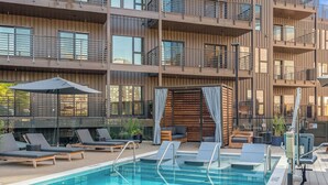 A rooftop pool with lounge chairs and a wooden deck. - Two Hyve Homes, One Epic Nashville Stay (Nashville)