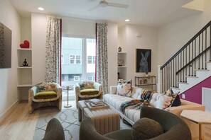 A living room with a sofa, armchairs, a coffee table, and a staircase. - Double the Homes, Minutes from Broadway (Nashville)