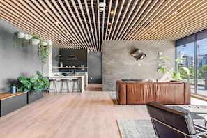 A modern interior with a kitchen, seating area, and large windows. - Downtown Nashville Duo | Sleeps 16 | Near Broadway (Nashville)