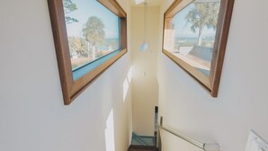 A narrow staircase with wooden steps and two large windows on either side. - Rooftop Oasis in Historic St. Augustine | Panoramic Intracoastal Waterway Views (St. Augustine)