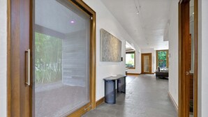 A hallway with a sliding glass door, a bench, and a painting on the wall. - Rooftop Oasis in Historic St. Augustine | Panoramic Intracoastal Waterway Views (St. Augustine)