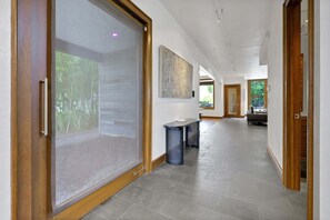 A hallway with a sliding glass door, a bench, and a painting on the wall. - Rooftop Oasis in Historic St. Augustine | Panoramic Intracoastal Waterway Views (St. Augustine)