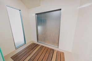 A room with a wooden floor, a sliding door, and a large window with a frosted glass panel. - Rooftop Oasis in Historic St. Augustine | Panoramic Intracoastal Waterway Views (St. Augustine)