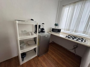 A compact kitchenette with a microwave, blender, and small refrigerator.