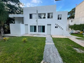 A modern two-story building with a flat roof, large windows, and a central staircase. - Casa Balam Cayo Lobo (Cancún)