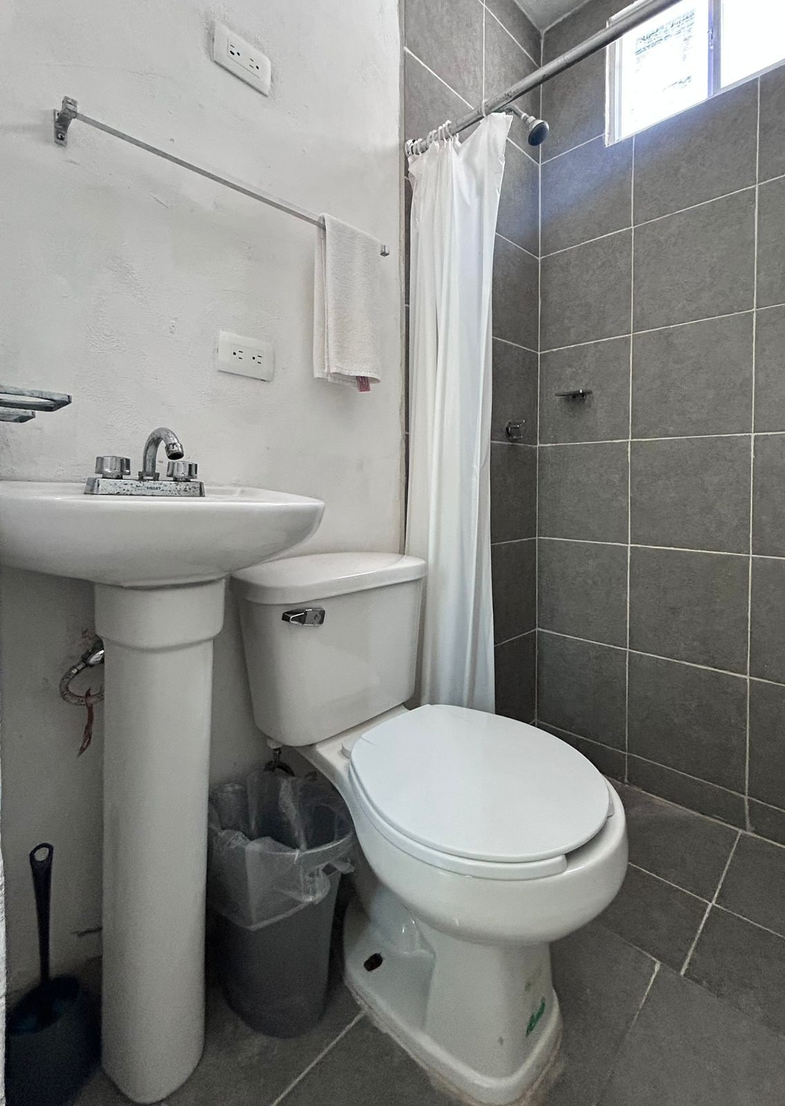 A bathroom with a white sink, toilet, and shower curtain.