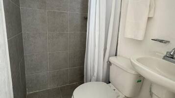 Departamento estándar, patio, vista al jardín | Baño | Regadera, toallas, papel de baño