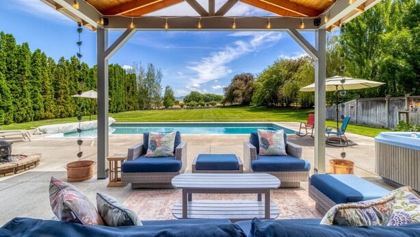 An outdoor patio with a covered seating area, a pool, and a hot tub. - Spacious Country Retreat | Pool • Hot Tub • Sauna • 5 King Bedrooms (Walla Walla)