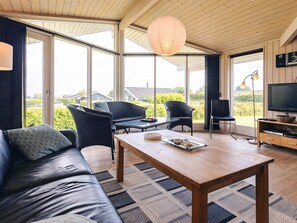 A modern living room with a sofa, a coffee table, and a television. - 4 Star Holiday Home in Rudkobing (Rudkobing)