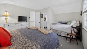 A bedroom with a bed, a chair, a television, and a dresser. - Charming Single-Family Beach Retreat in the Heart of Ocean City (Ocean City)