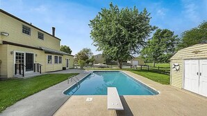 A residential setting with a swimming pool, a covered patio, and a garage. - Cozy 1-bedroom 1-bathroom suite in enchanting Rossford with AC (Rossford)
