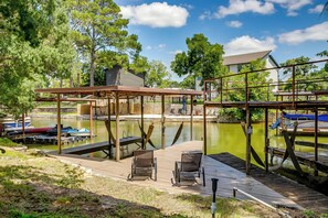 A dock with chairs, a covered area, and boats in the background. - Lakeside Granbury Home w/ Huge Backyard and Dock (Granbury)