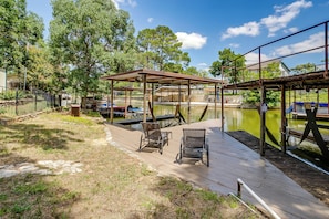 A wooden dock with chairs, a covered seating area, and a pond. - Lakeside Granbury Home w/ Huge Backyard and Dock (Granbury)