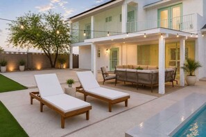 Ein modernes Haus mit Pool, Außenbereich und Lichterkette.