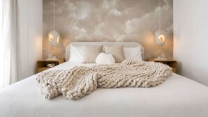 A bedroom with a bed, a textured wall, two bedside tables, and hanging pendant lights. - LUX 8BR/4.5BA Resort-Style Villa w/Pool+Spa · sleeps 20 (Las Vegas)