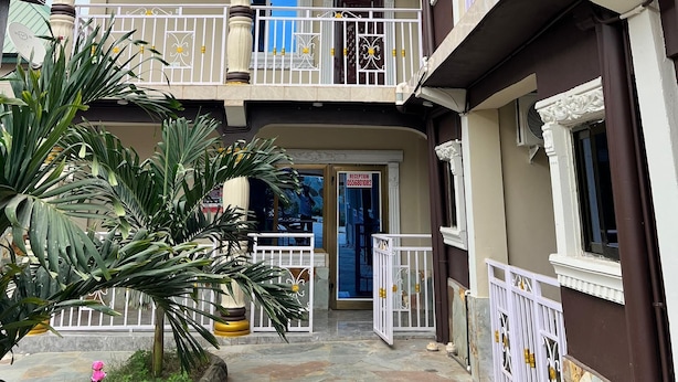 A multi-story building with balconies, a reception area, and a gated entrance. - ESTHEMERS ROYAL HOTEL (Kumasi)
