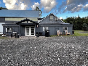 A two-story building with a gravel driveway, a front door, and two windows. - Charming 3BR Country Retreat on 5 Private Acres Near Williamstown (Williamstown)