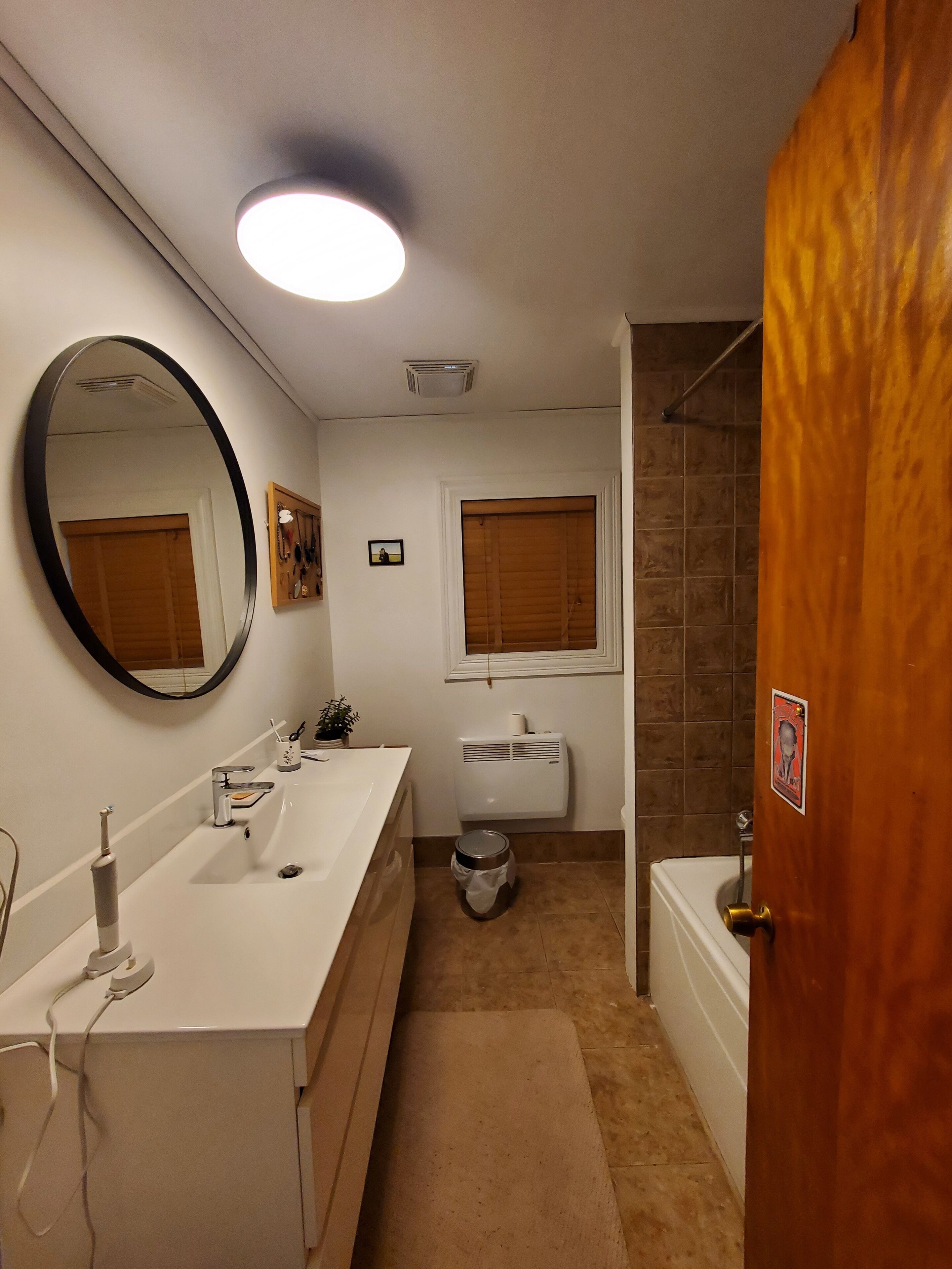 Un baño con lavamanos blanco, espejo, inodoro y ducha.