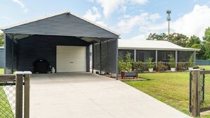 Un bâtiment doté d’un garage fermé, d’un espace clôturé et d’une véranda grillagée.