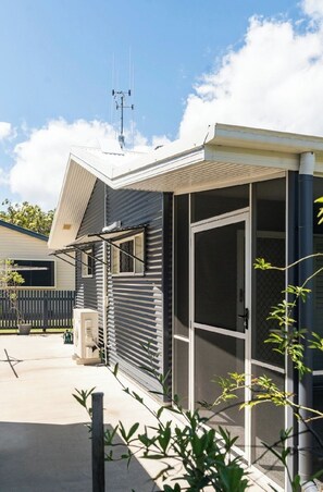 A residential building with a large window, a door, and a satellite dish. - Coastal Calm on the Fraser Coastl (Poona)
