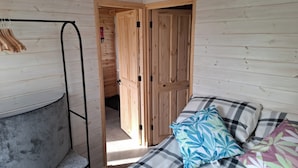 Une chambre avec un lit, une armoire et un portant à vêtements.