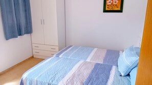 A bedroom with a bed, a wardrobe, and a painting on the wall. - Beautiful House, Sleeps 7 With Private Pool (Iznajar)