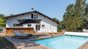 A modern house with a swimming pool, deck chairs, and a wooden deck. - Villa Atlantide - Welkeys (Moliets-et-Maa)