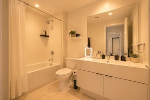 Ein modernes Badezimmer mit Badewanne, Toilette und Waschtisch mit Spiegel.