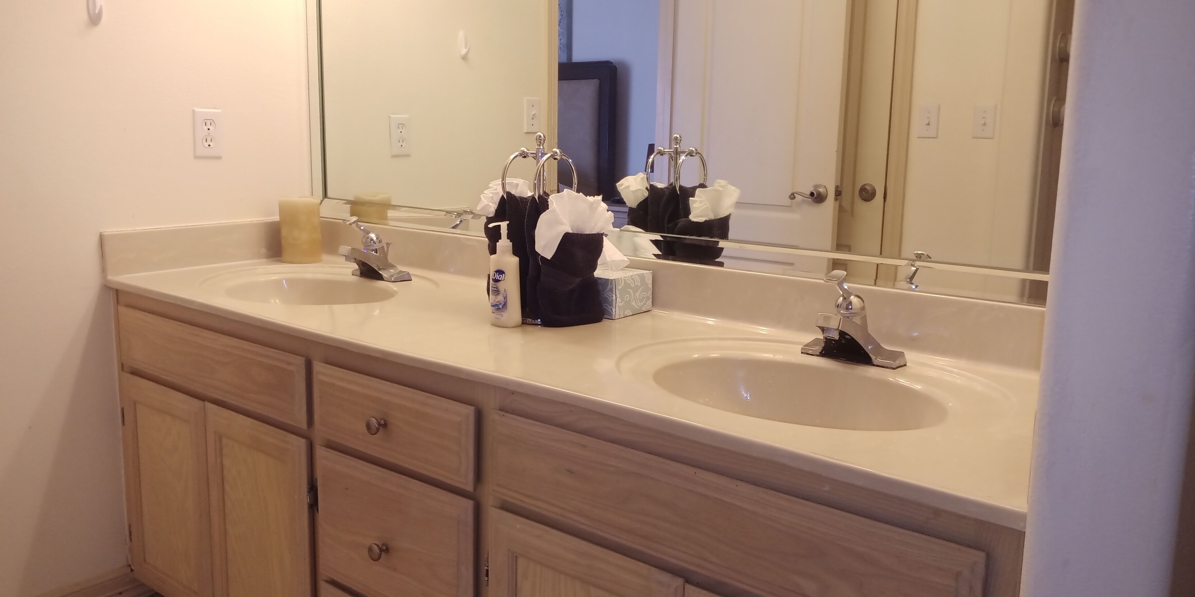 A bathroom with two sinks, a mirror, and a towel rack.