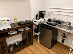 A compact kitchenette with a microwave, stove, coffee maker, and dishwasher. - Private beautiful Suite in Bungalow (Brossard)
