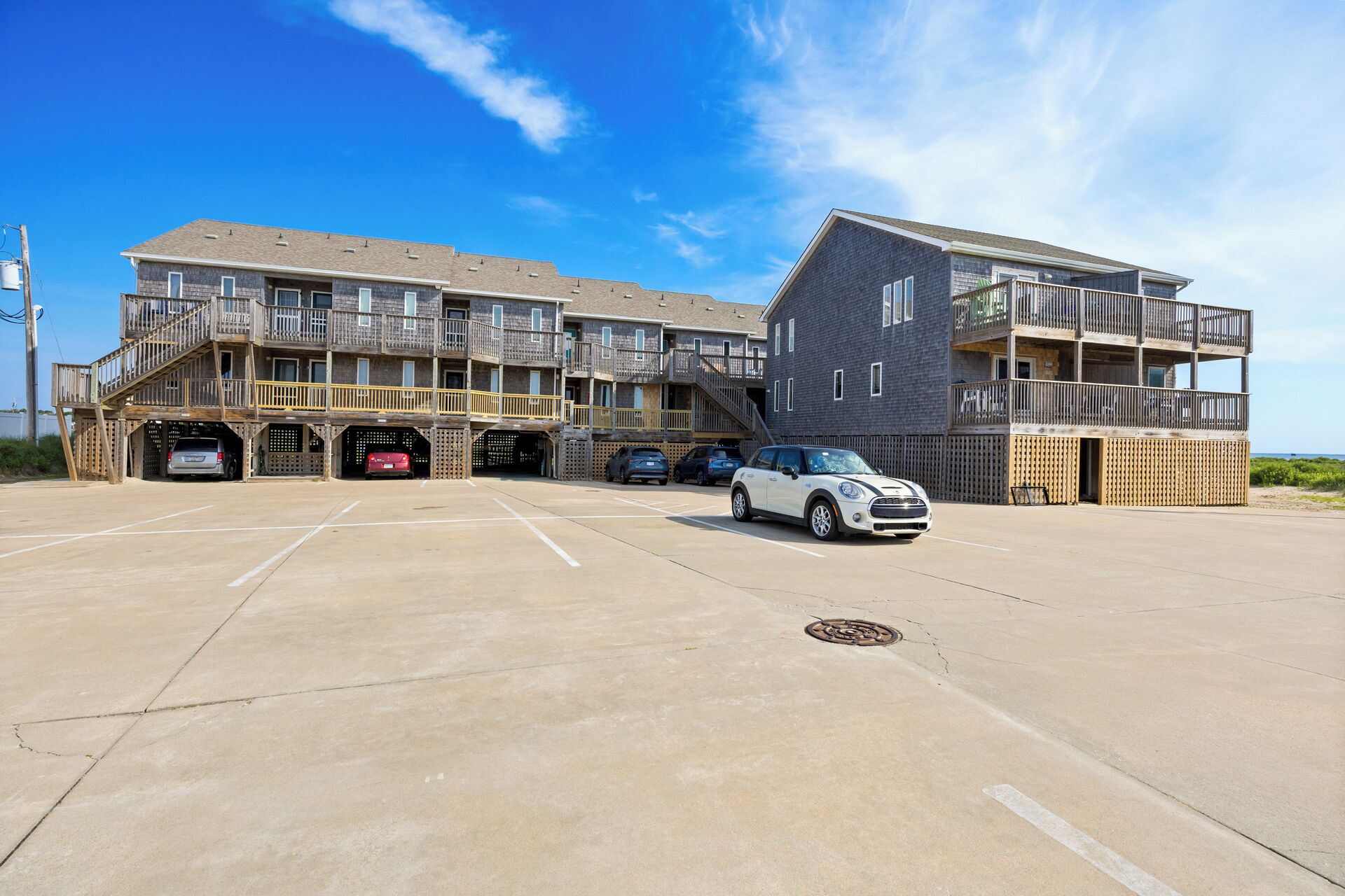 A multi-story building with a parking lot in front.