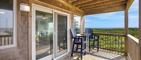 A covered outdoor area with a wooden deck, a table, and chairs.