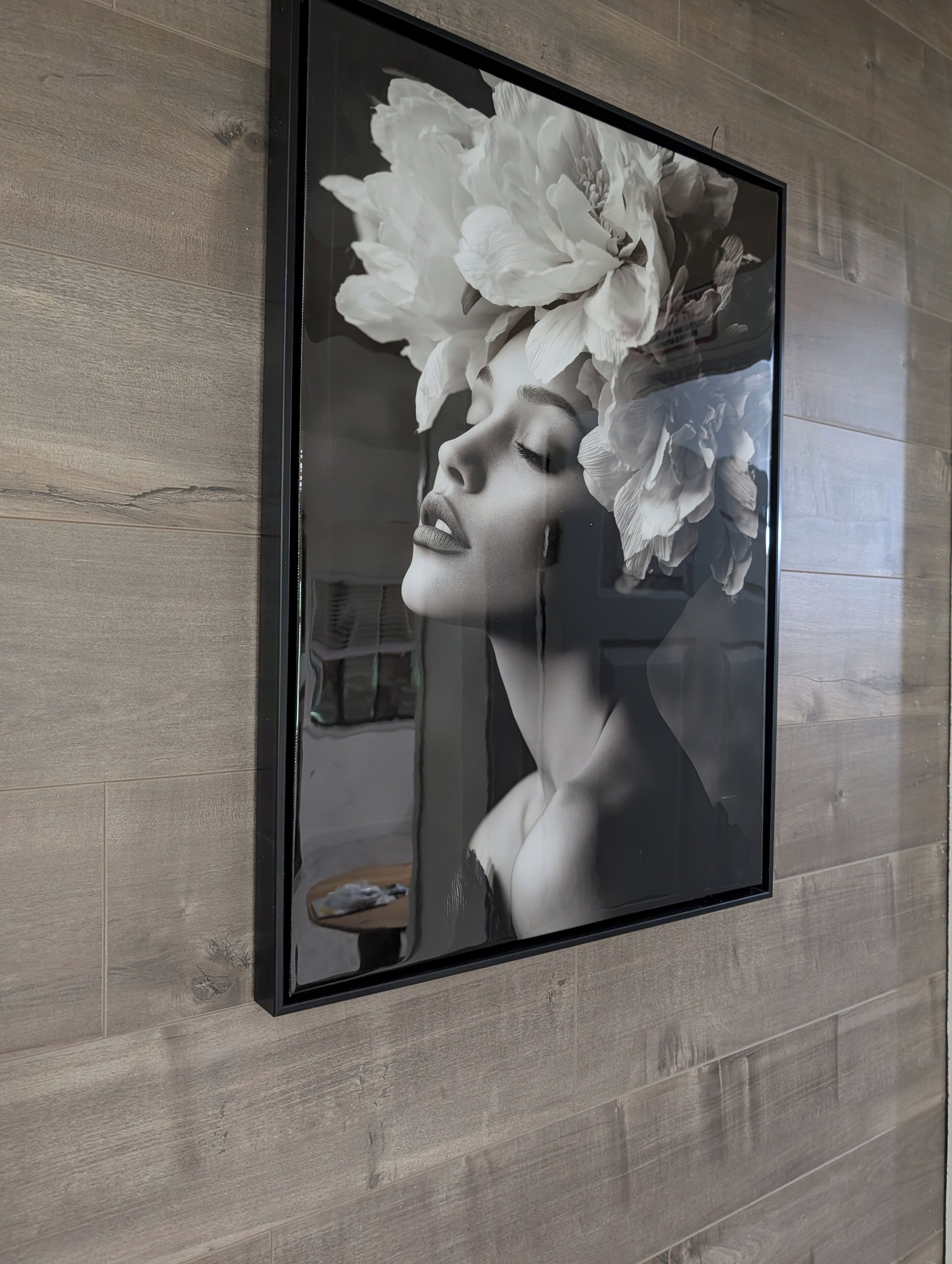A framed artwork of a floral design on a wall.