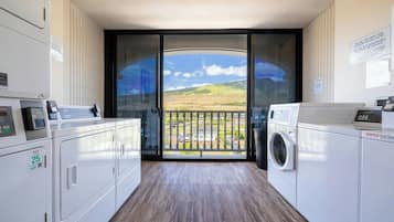 A laundry room with a view of a landscape through a glass door.