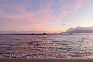 Una playa con aguas tranquilas y un cielo al atardecer.