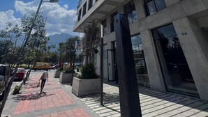 Ein modernes Gebäude mit einem markanten 'CORNER'-Schild, großen Fenstern und blauem Himmel.