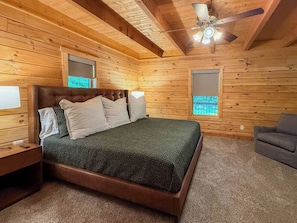 A wooden-paneled bedroom with a bed, nightstands, a ceiling fan, and a window. - Secluded log home! The Falcone Lodge (Marshall)