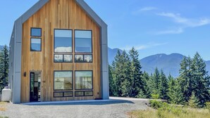 A modern wooden cabin with large windows and a view of mountains. - The Lookout | Wifi, AC, Modern (Packwood)