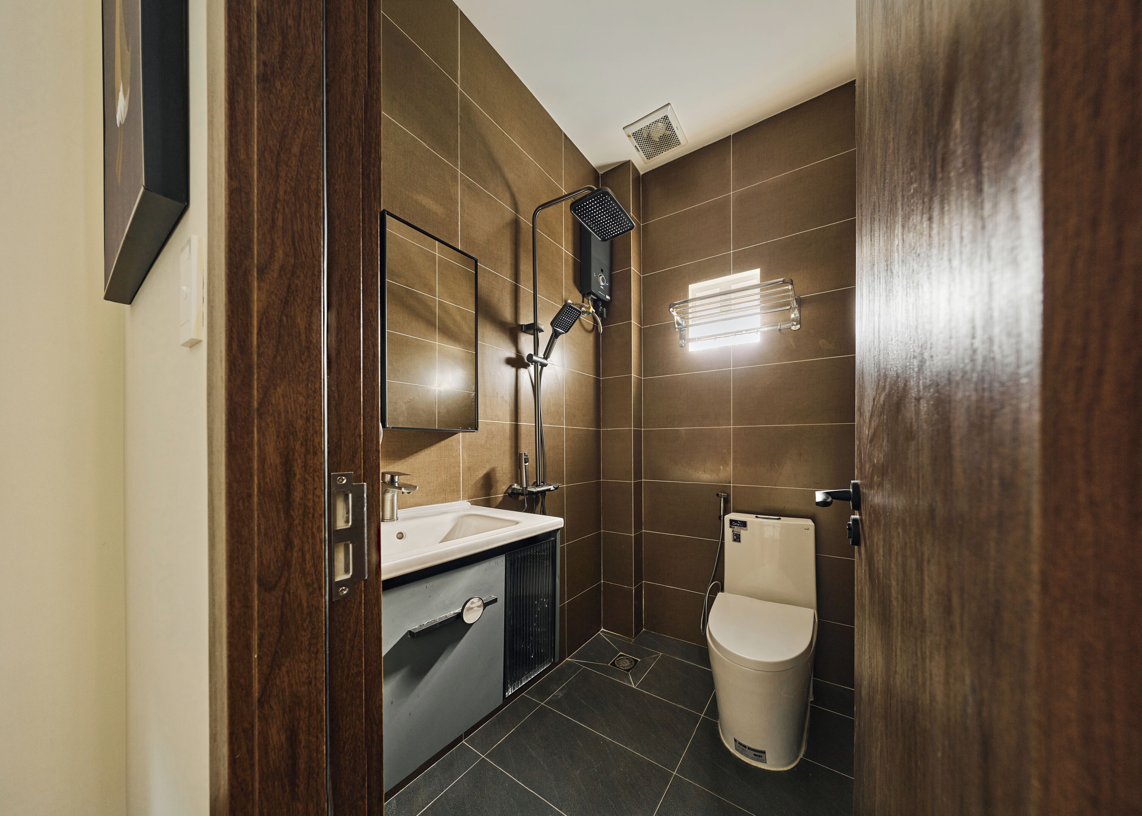 Une salle de bain moderne équipée d’une douche, de toilettes, d’un lavabo et d’un miroir.