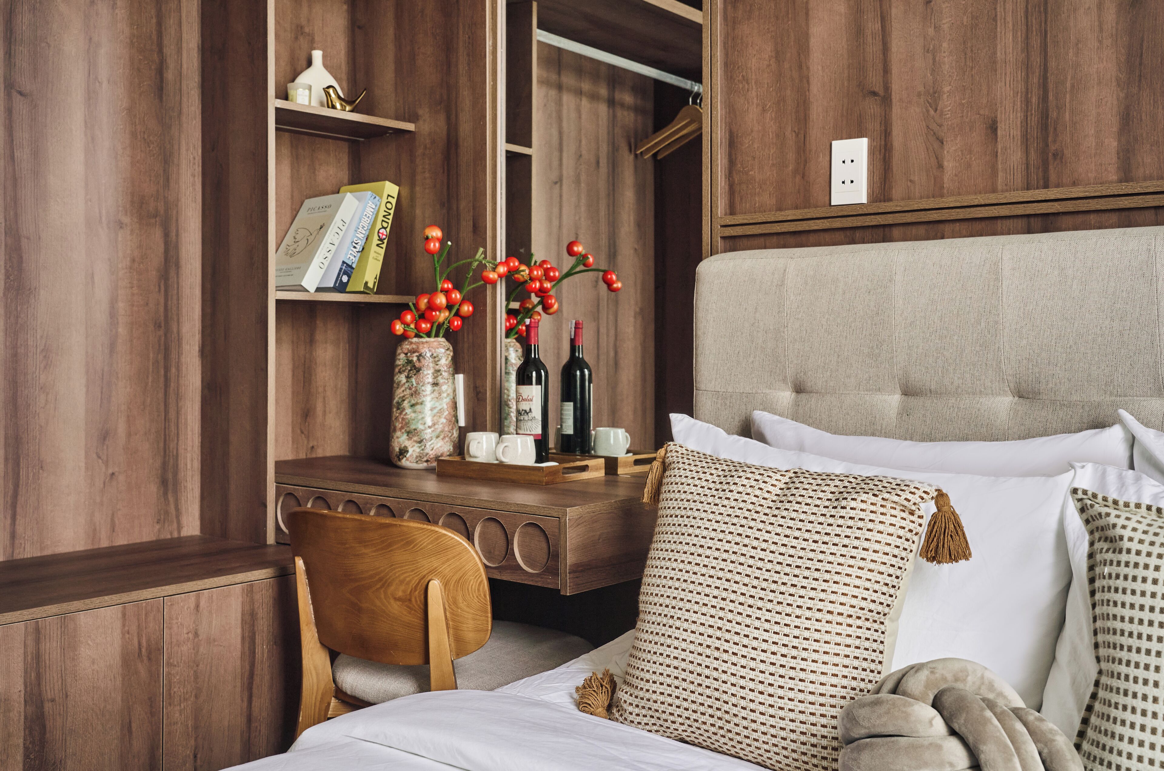 A wooden-paneled room with a bed, a wooden desk, and a chair.