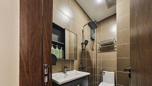 A modern bathroom with a sink, mirror, toilet, and shower. - Centoria Hotel Quang Trung by Urban B (Ho Chi Minh City)